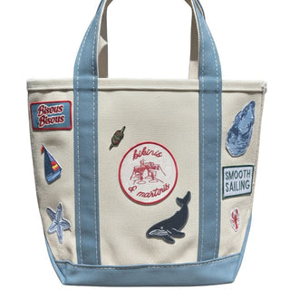 Canvas tote bag with various patches and designs on a white background