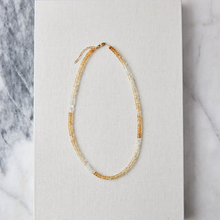 yellow citrine Necklace on a white card with a marble background