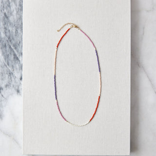 Necklace on a white card with a marble background