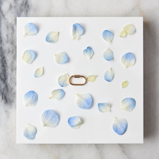 Carabiner with blue and white floral decorations on a marble surface
