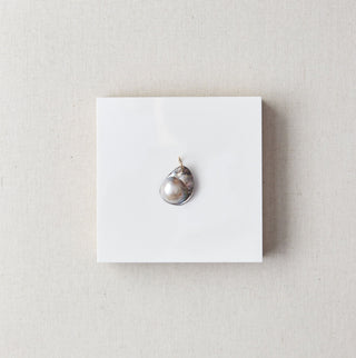 Mobe pearl pendant on a white card with a marble background