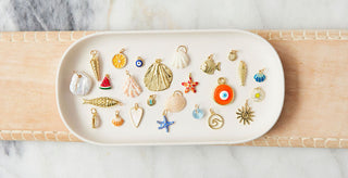 Assorted charms on a white tray with a marble background