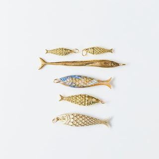 Set of gold fish-shaped jewelry on a white background