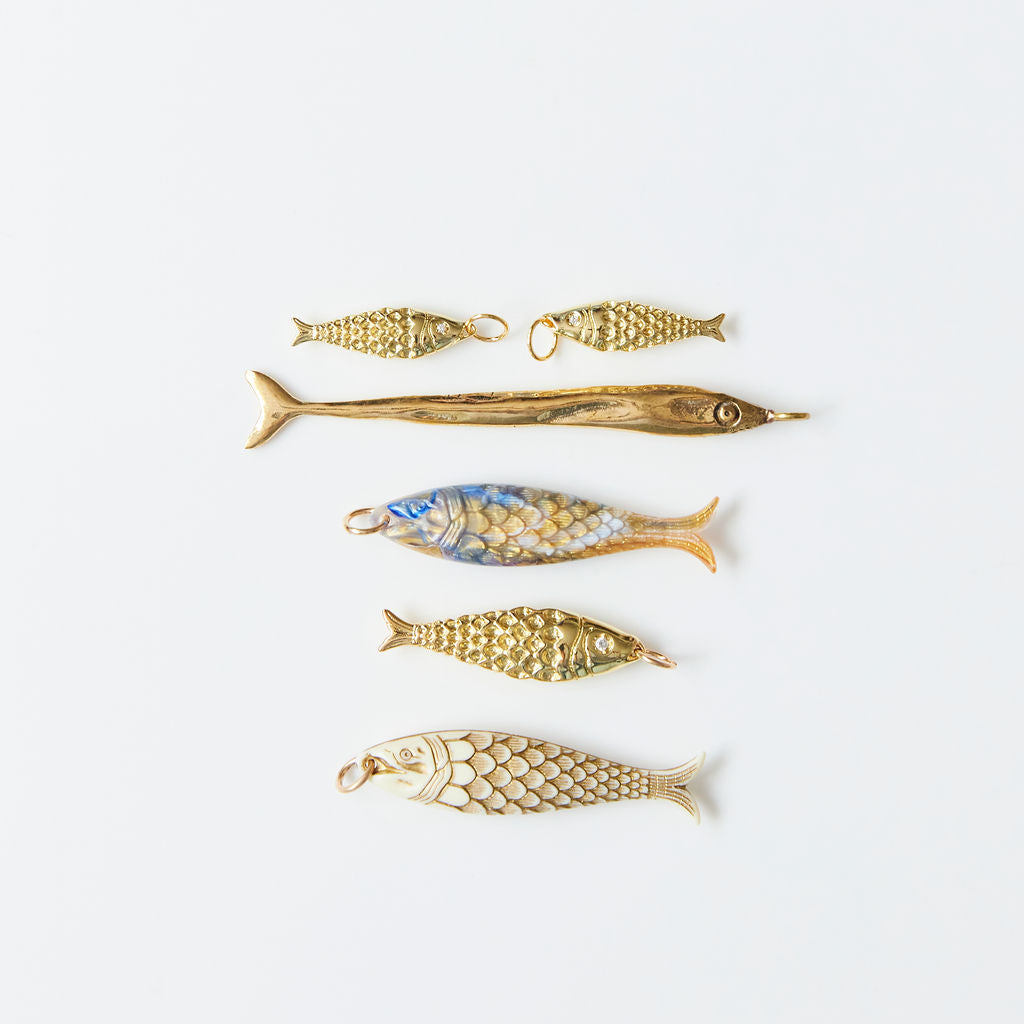Set of gold fish-shaped jewelry on a white background