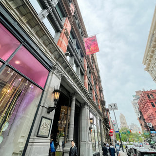 City street scene with a building facade and pedestrians on a cloudy day.