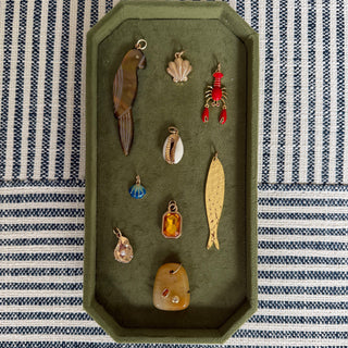 Collection of vintage fishing lures on a green tray with a striped background