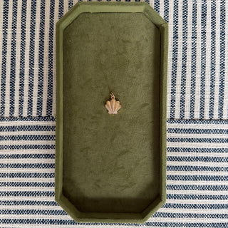 Green rectangular tray with a small decorative item on a striped fabric background