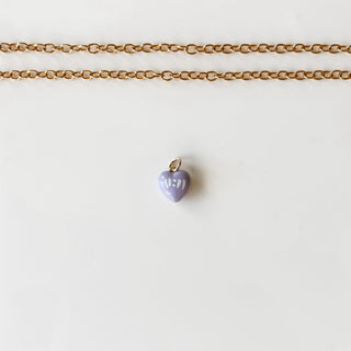 Gold chain necklace with a hand painted 11:11 purple heart pendant on a marble background