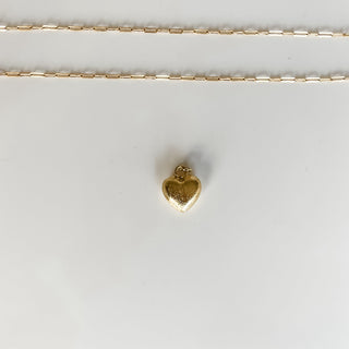 gold puff heart charm on white background