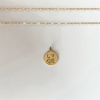 embossed love coin charm on white background