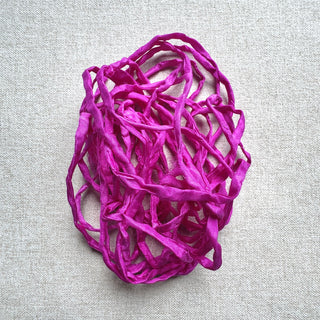 Fuchsia silk on a light grey linen fabric background