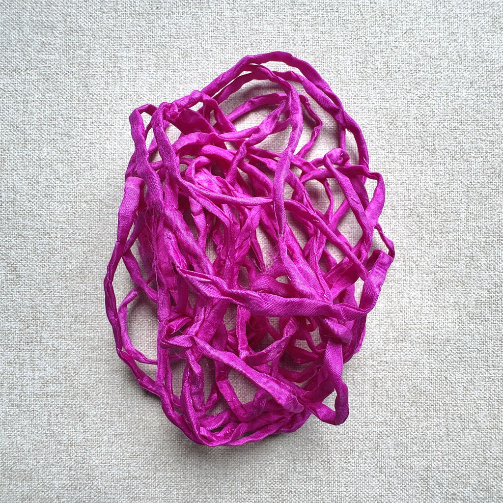Fuchsia silk on a light grey linen fabric background