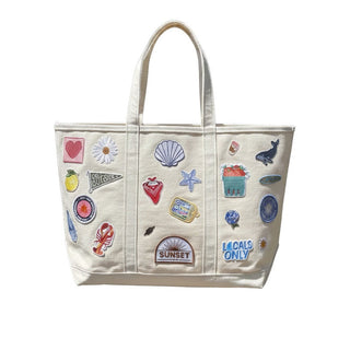 Beige tote bag with various colorful patches on a white background