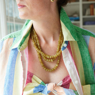 Person wearing a colorful jacket over a pink top with a bow, indoors.