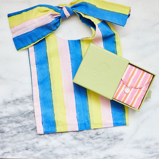 Colorful striped fabric with a bow and a small box on a marble surface