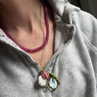 Necklace with a pendant worn by a person in a gray shirt