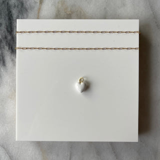 white puff heart charm on white background